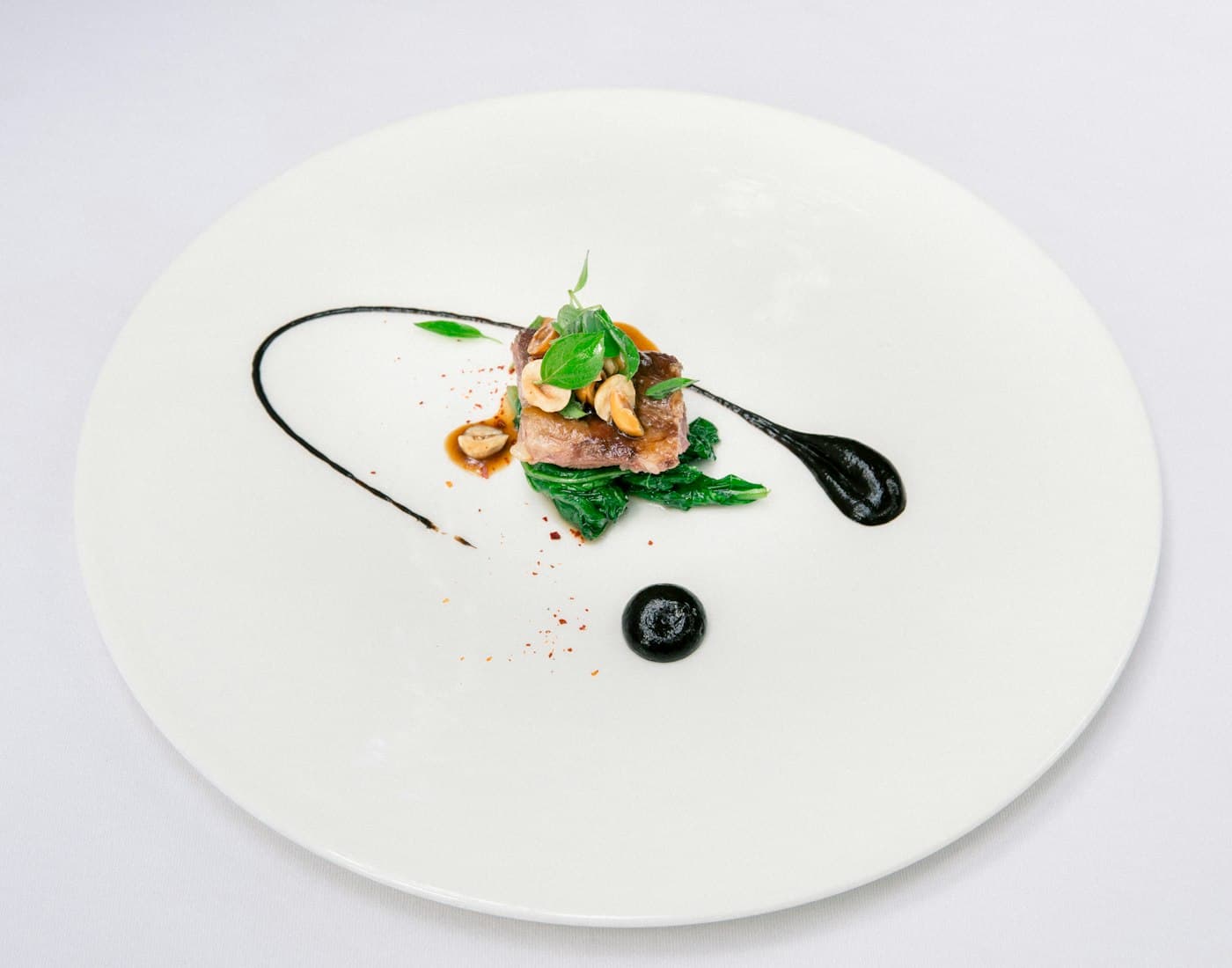 Plated spring asparagus dish with shaved black truffle, photographed from above.